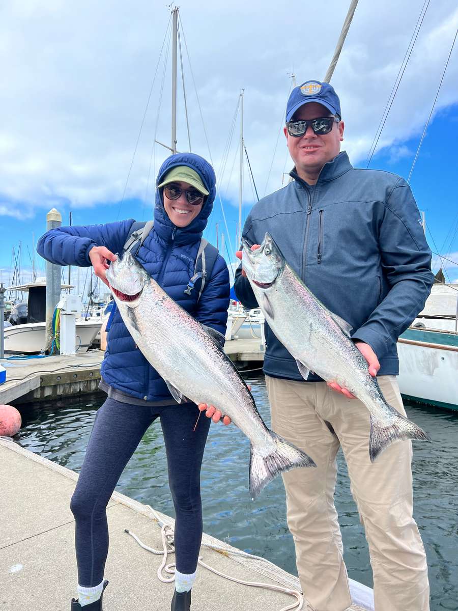 Why Choose Cut Plug Charters? Two smiling customers after a successful salmon fishing charter in Seattle with Cut Plug Charters.